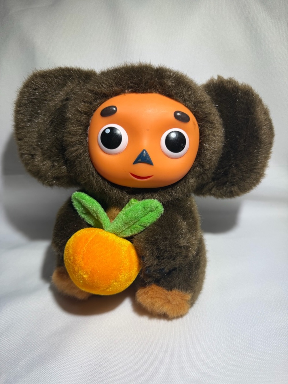 Plush Brown Character Toy with Orange Face and Orange Accessory